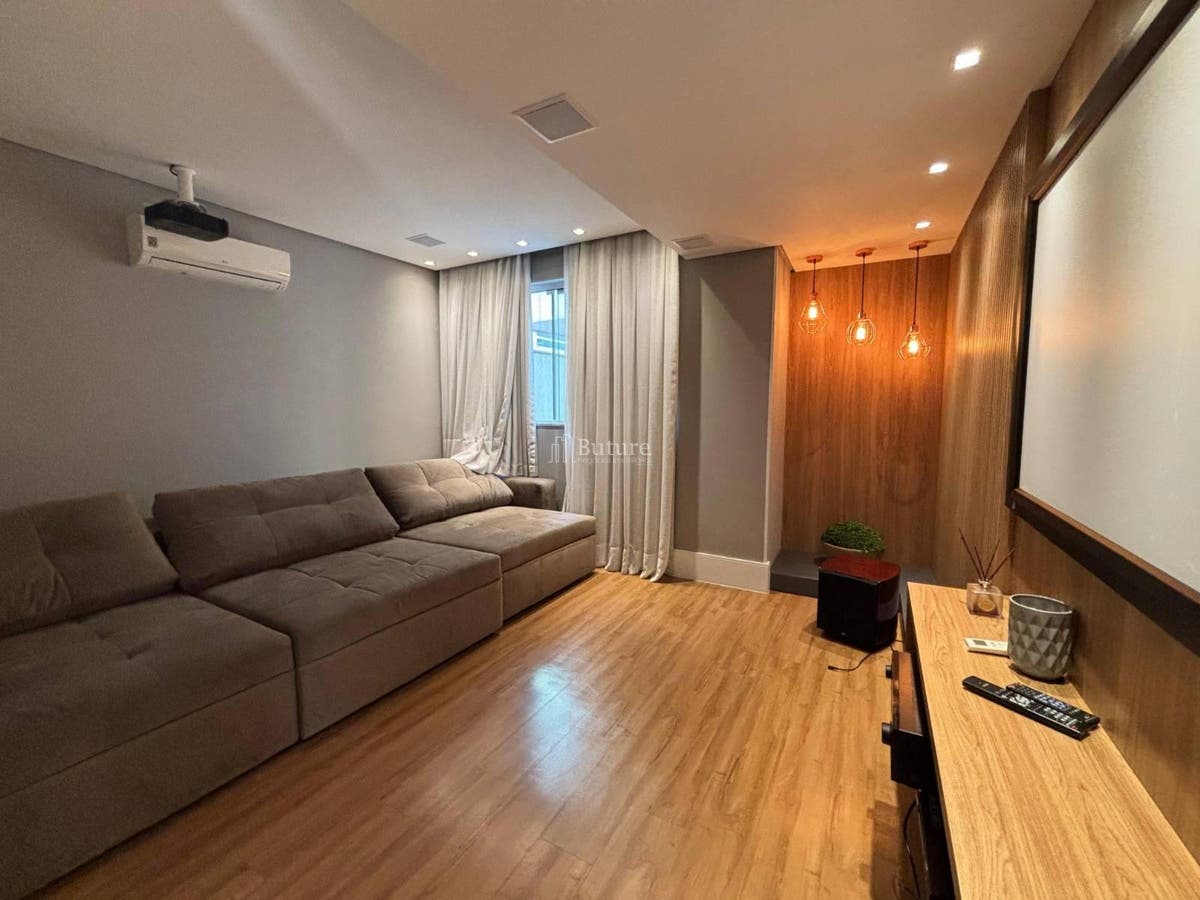 Sala com sofá, cortinas, piso de madeira, parede cinza, iluminação embutida