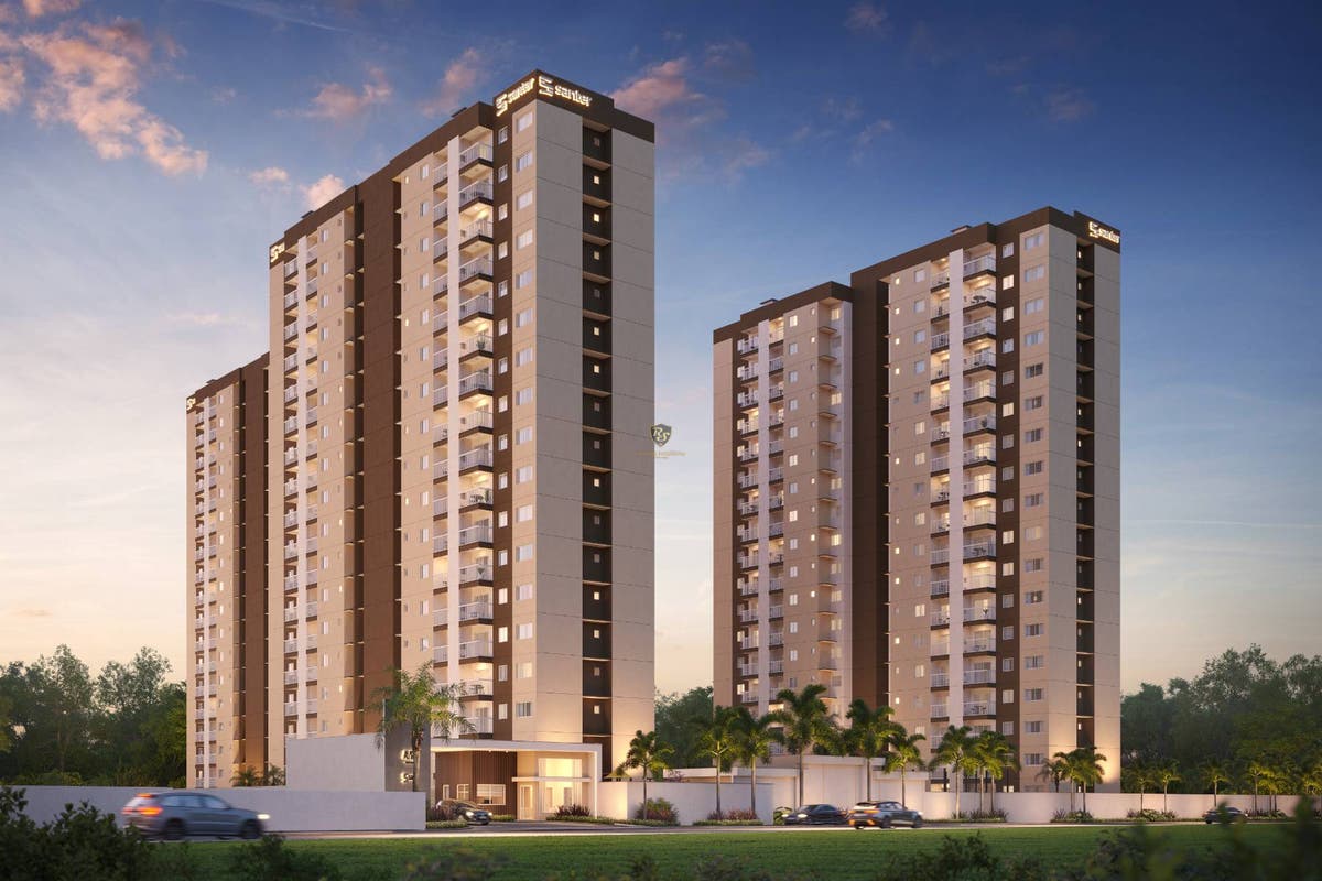 Prédio de apartamentos alto com fachada moderna e iluminação acesa à noite