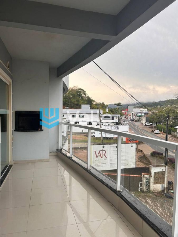 Varanda com piso claro, vista para rua, proteção de vidro e pintura clara