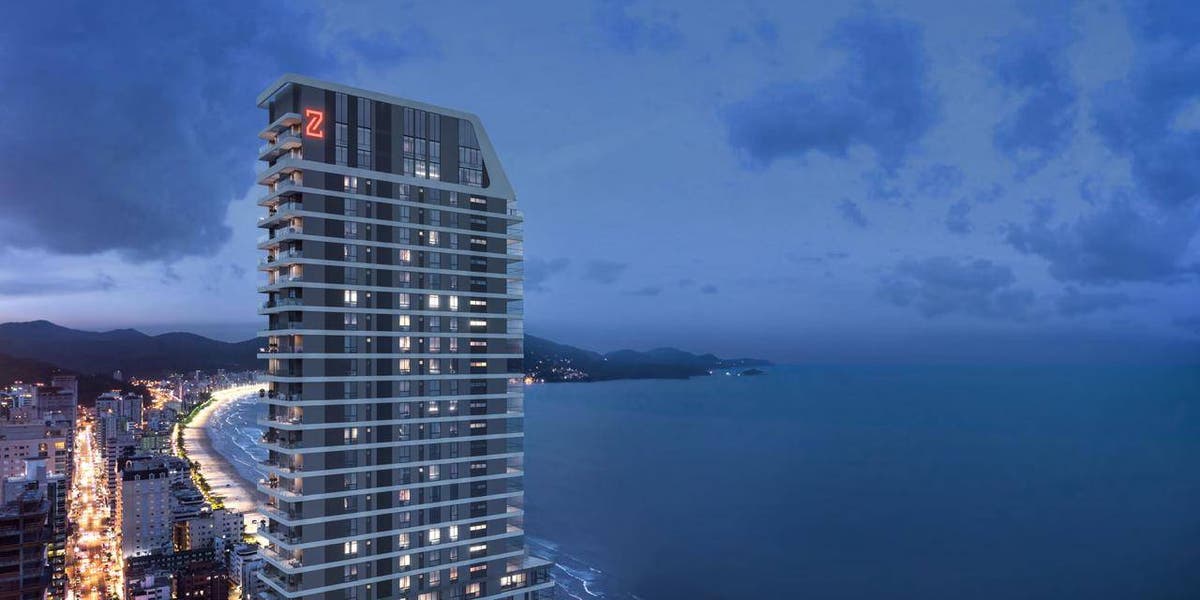Vista de um prédio alto à noite ao lado do mar