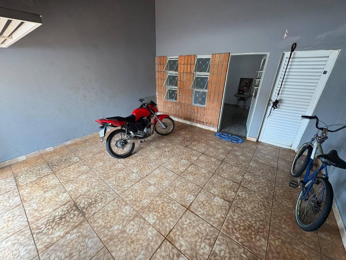 Varanda coberta com piso de cerâmica, parede lixa e ventilação natural.
