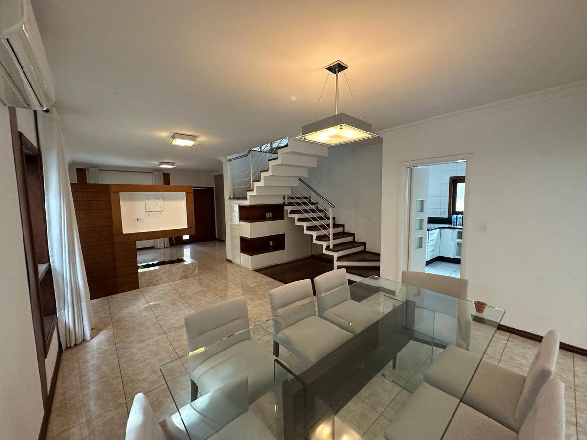Sala com piso de cerâmica, escada branca, iluminação artificial suave.