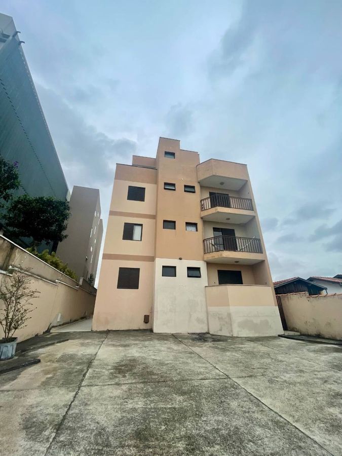 Edifício de várias alturas com fachada em tons de bege e detalhes pretos