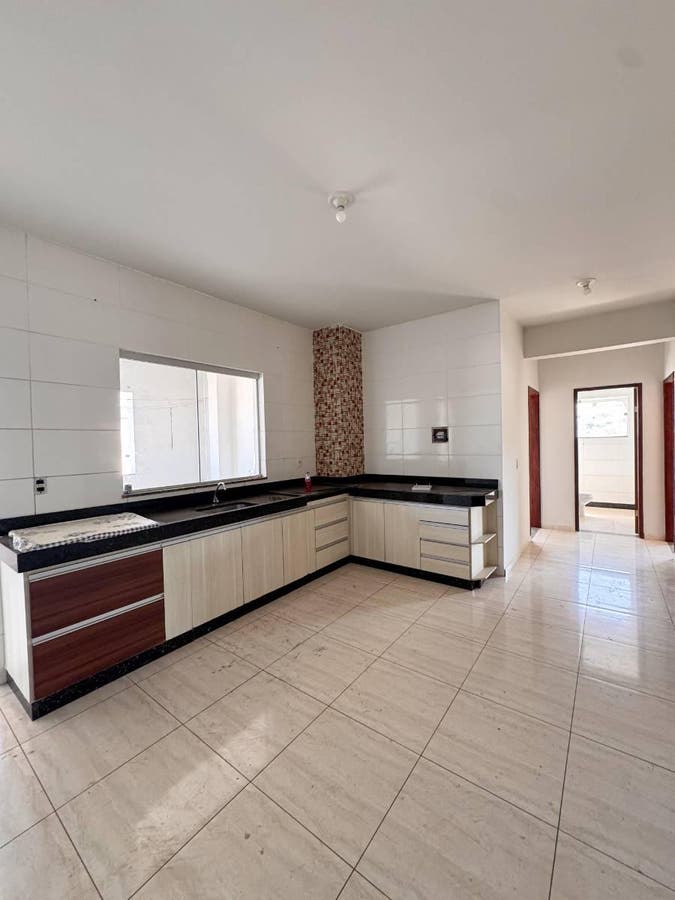 Cozinha com bancada de granito, azulejos brancos e piso de cerâmica.