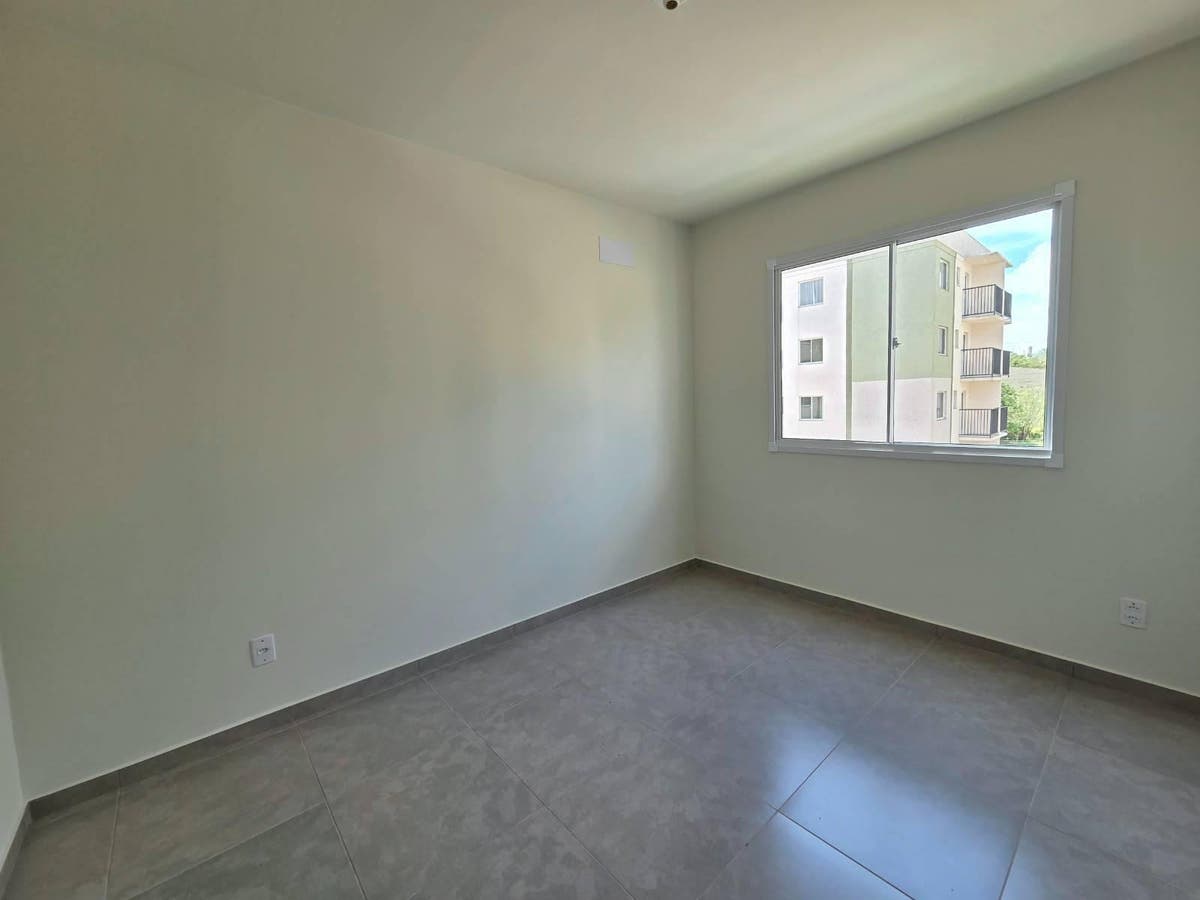 Quarto vazio com parede branca e janela de vidro grande