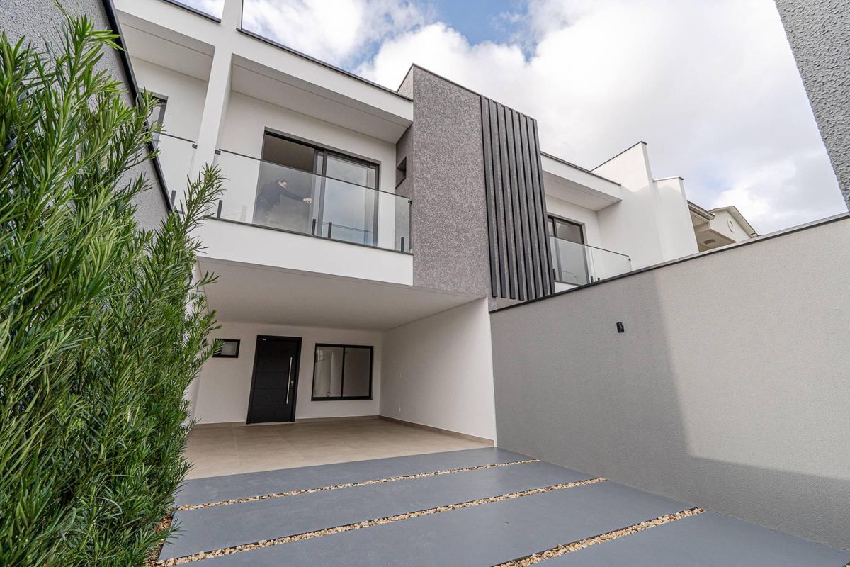 Vista frontal de residência moderna com fachada branca e detalhes em cinza