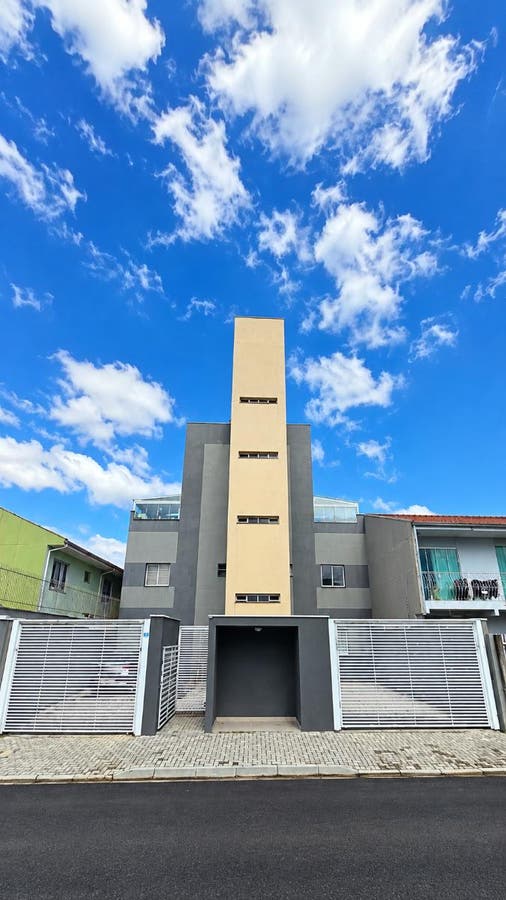 Fachada de edifício moderno de concreto e vidro sob céu azul