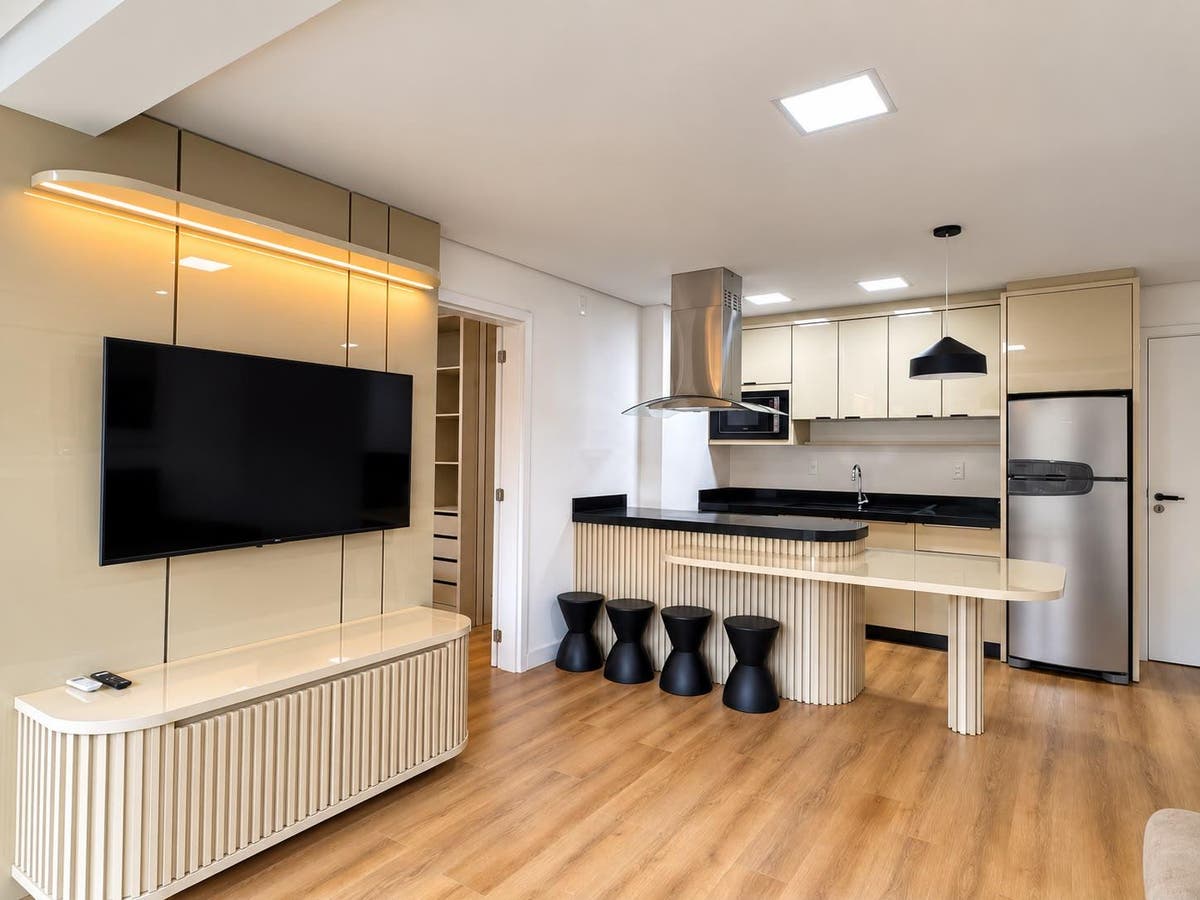 Cozinha moderna com armários bege, ilha e iluminação embutida