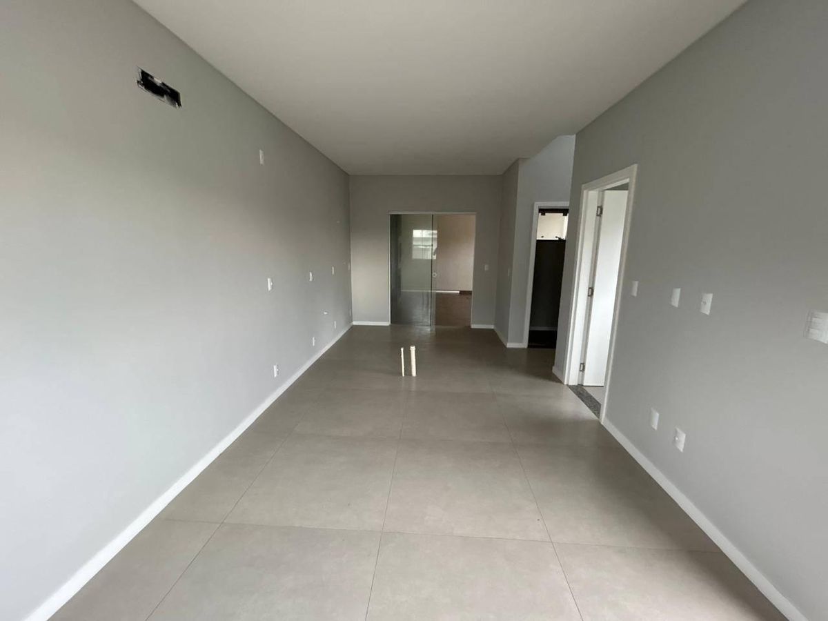 Sala de estar vazia com paredes cinza e piso de porcelanato claro