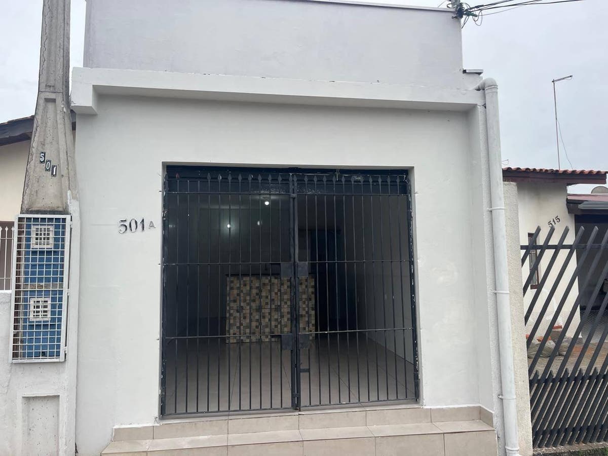 Fachada de casa com porta de ferro preta e detalhes em azulejos
