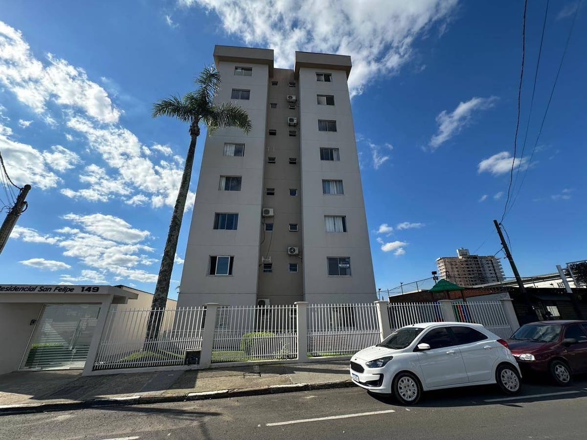 Edifício residencial de altura média com fachada branca e janelas pequenas