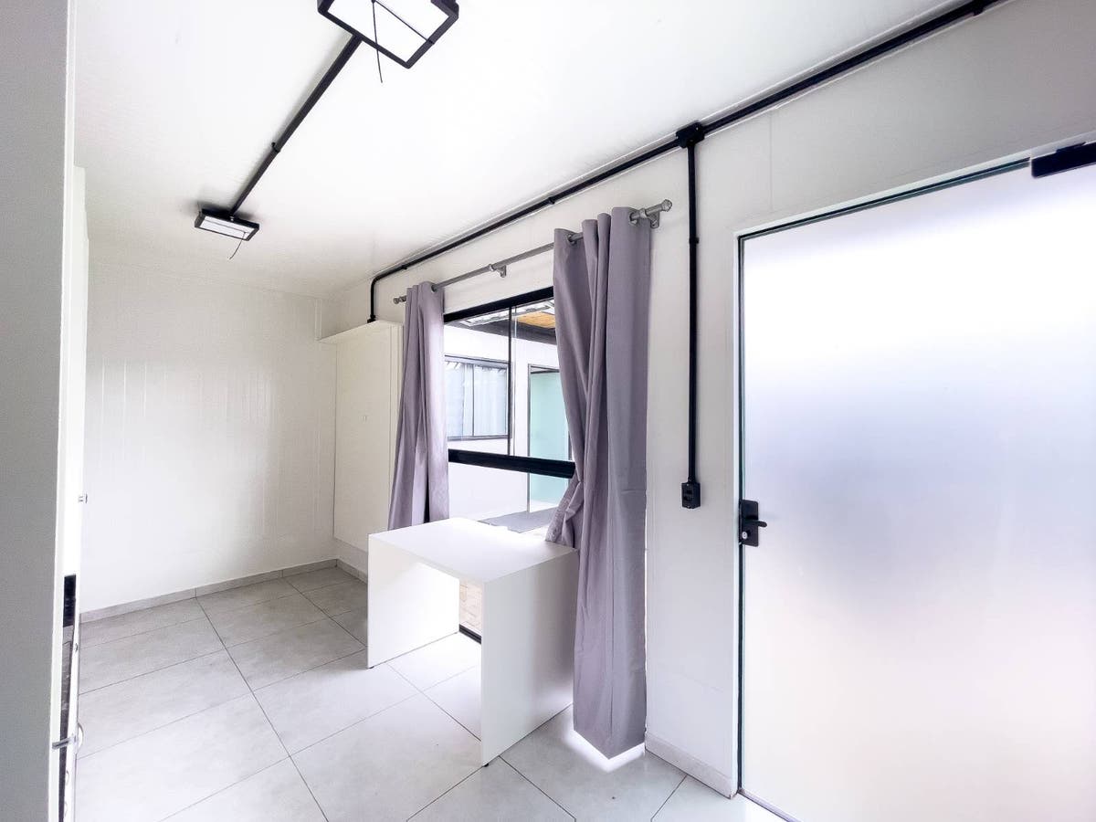 Ambiente interno com janela, cortinas lilás, parede branca, piso de cerâmica