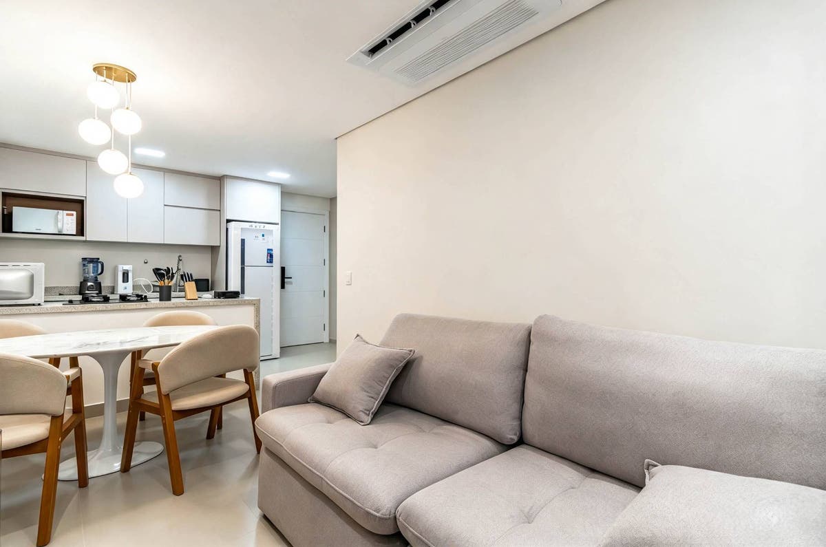 Sala integrada com cozinha, iluminação direta, acabamento branco fosco