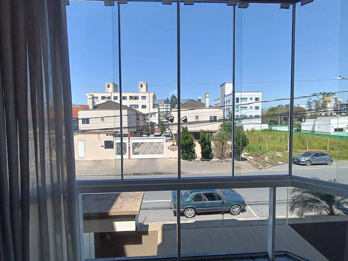 Janela com vista para rua, casas, céu, árvores, carros, bairro