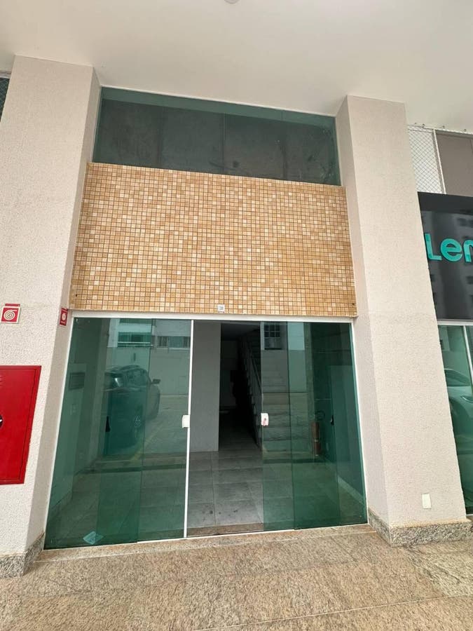 Fachada de edifício comercial com portas de vidro e revestimento de cerâmica