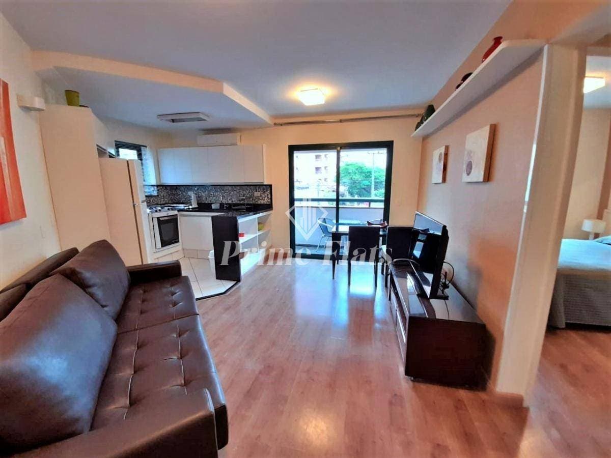 Sala de estar integrada com cozinha, piso de madeira e iluminação central