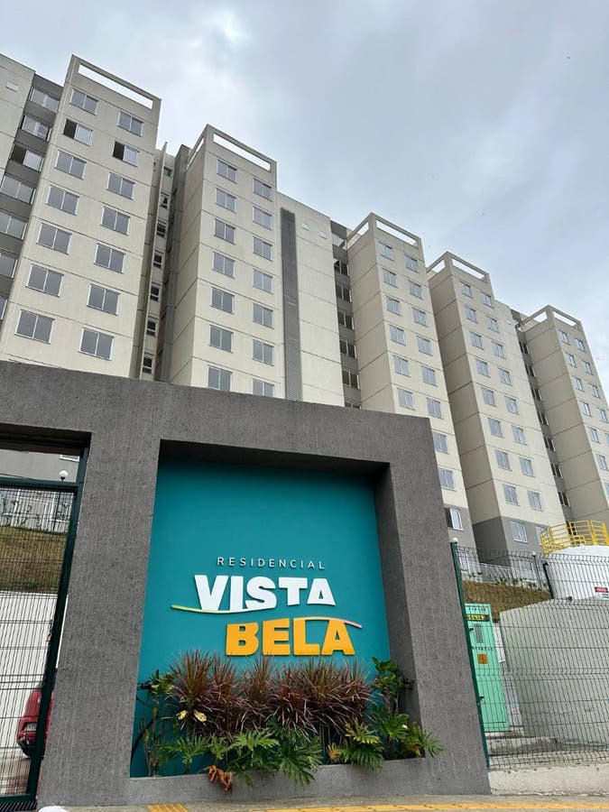 Edifício residencial de muitos andares com fachada cinza e janelas retangulares