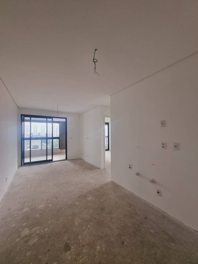 Sala vazia com paredes brancas e piso de concreto bruto