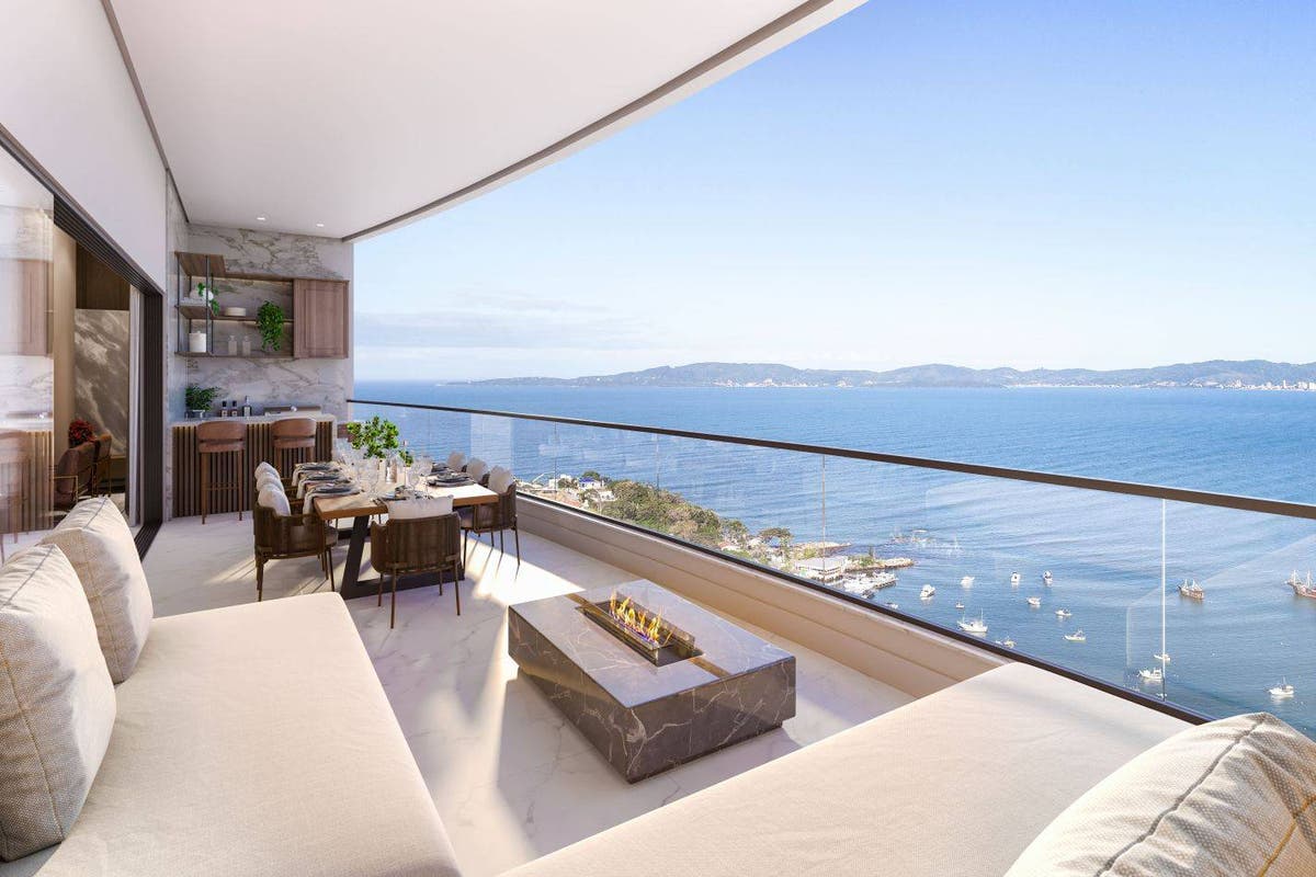 Varanda com vista para o mar e mobília moderna de acabamento em mármore.