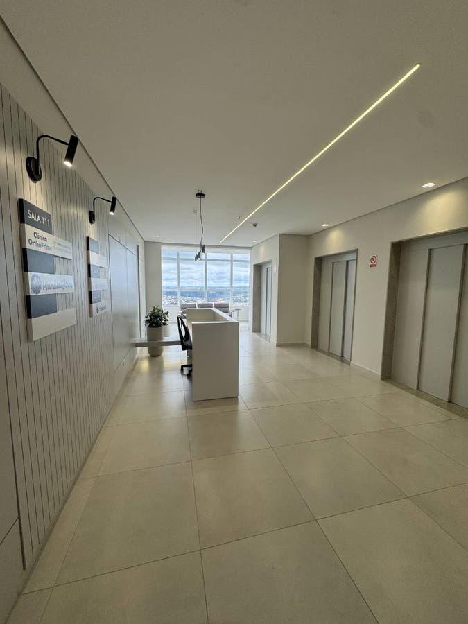 Hall de entrada com piso de porcelanato, paredes brancas, iluminação embutida.