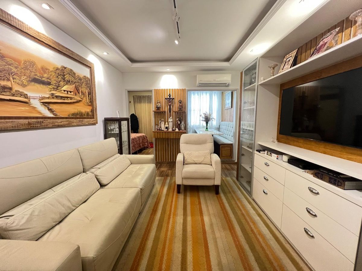 Sala de estar com móveis, quadro, cortinas e piso de madeira clara