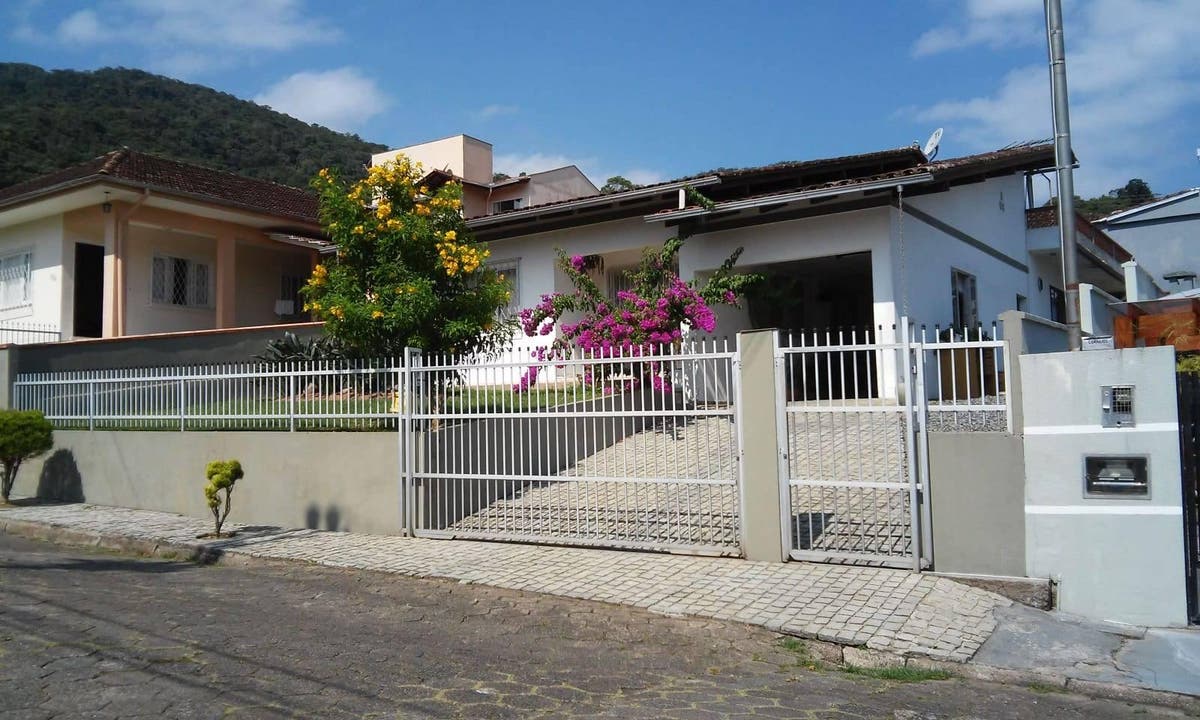 Fachada de casa com jardim e cerca branca