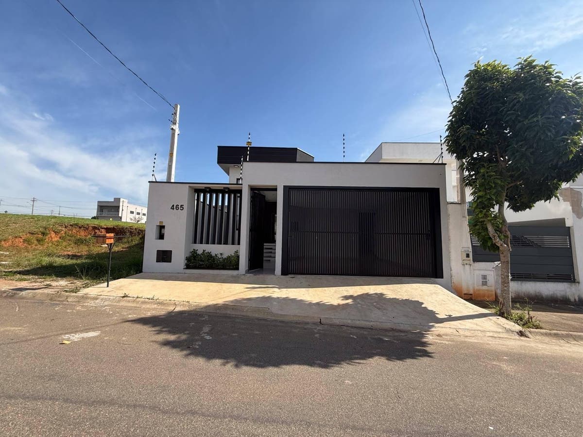fachada de casa moderna com portão preto e árvore ao lado