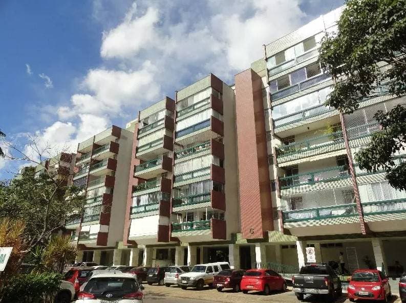 Prédio de apartamentos com fachada de alvenaria e varandas de vidro