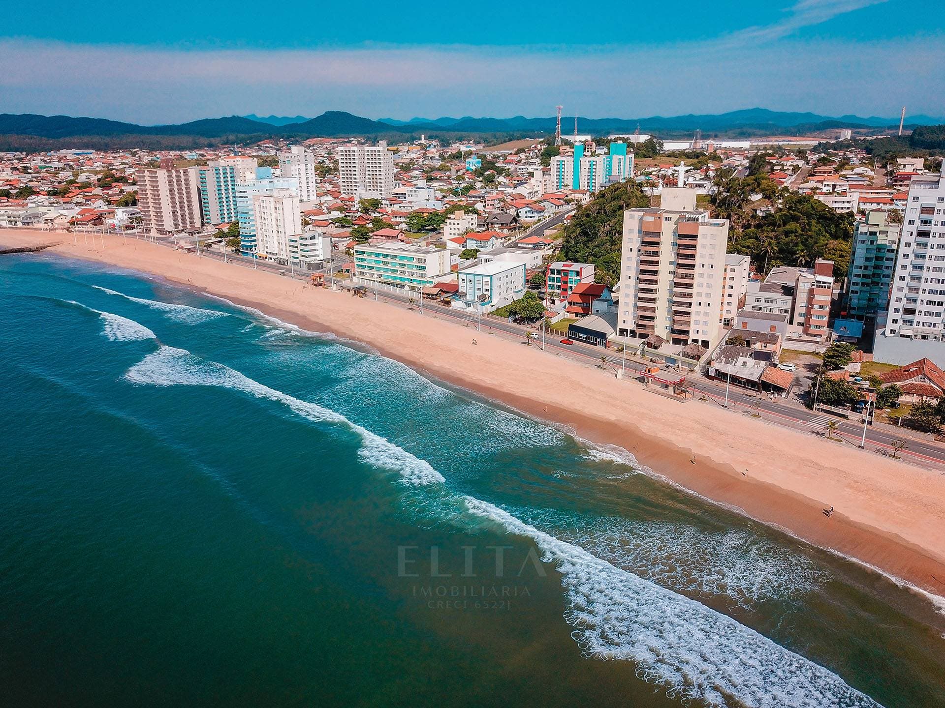 Vista aérea da Praia Central com avenida, faixa de areia e edifícios de Barra Velha