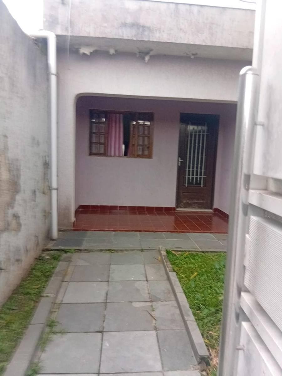 Escadaria de entrada com parede de tijolos e porta de madeira