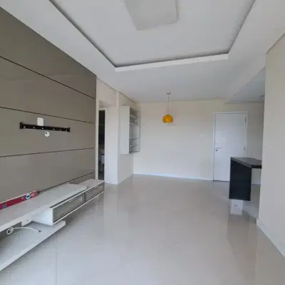 Sala com teto rebaixado, acabamento em tinta clara e piso porcelanato.