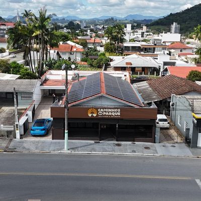 Igreja com telhado de telhas vermelhas e painéis solares, rua em frente