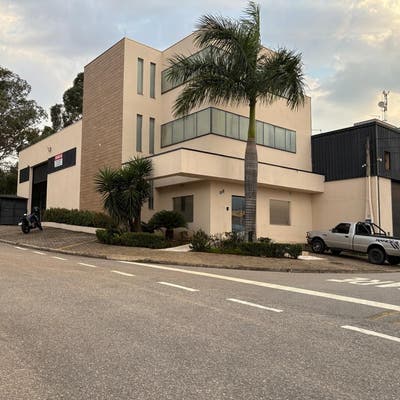 Prédio moderno de linhas retas com fachada branca e detalhes em madeira.