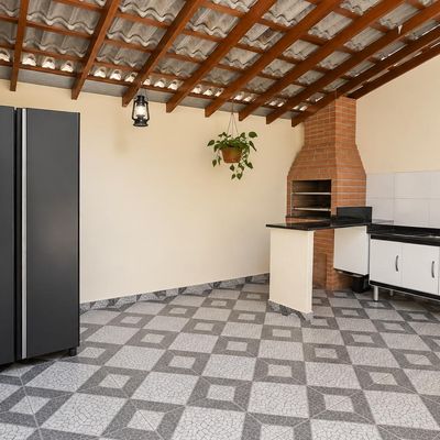 Cozinha com armário e churrasqueira em ambiente coberto com teto de madeirame.