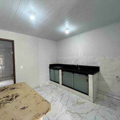 Cozinha com bancada preta e revestimento de paredes em mármore branco
