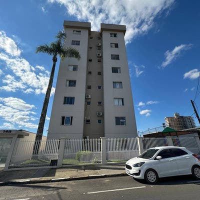 Edifício residencial de altura média com fachada branca e janelas pequenas