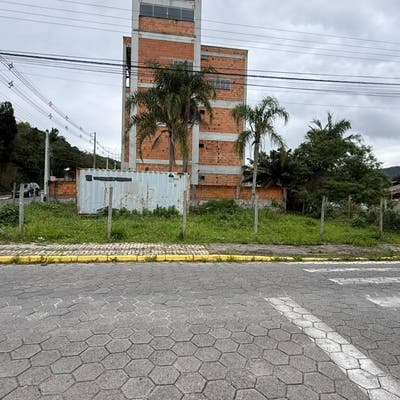 Prédio de apartamento em construção com árvores ao redor.