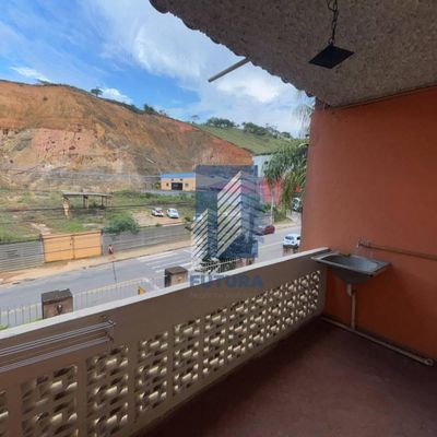 Varanda com parede laranja, pia e vista de morro ao fundo