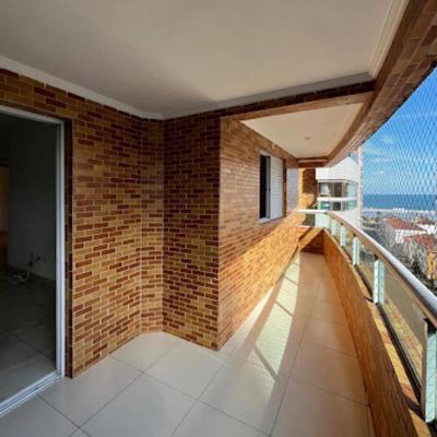 Varanda com paredes de tijolos, piso de revestimento claro, vista para o céu