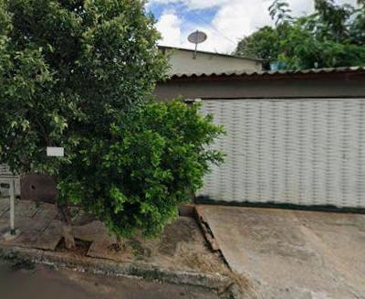 Fachada de residência com garagem e árvore ao lado