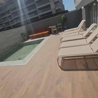 Varanda com piscina, cadeiras de sol e móveis de exterior em edifício alto