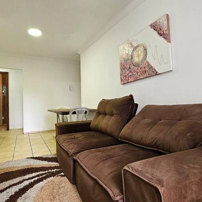 Sala de estar com piso de cerâmica e móveis estofados.