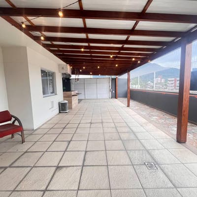 Varanda ampla com piso de cerâmica, teto de madeira, varanda de vidro.