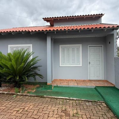 Casa com porta, janela, telhado de barro e parede cinza
