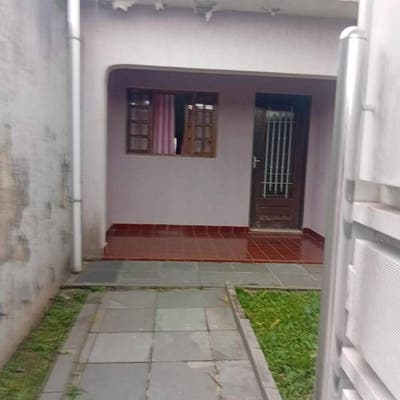 Escadaria de entrada com parede de tijolos e porta de madeira